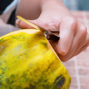 pelare o sbucciare papaya con coltello 